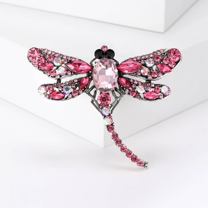 Detailed macro view of dragonfly brooch featuring pink crystals and silver metal finish