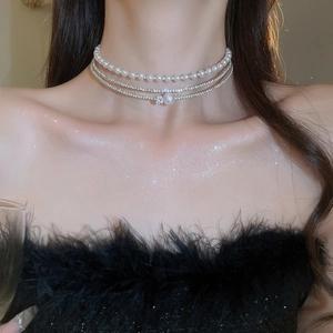 Close-up of elegant multi-layer pearl choker with sparkling rhinestones on model neck