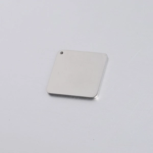 Macro shot of mirror-polished square stainless steel tag with rounded corners and top hole