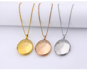 Three polished heart-shaped locket pendants in gold, rose gold and silver finishes