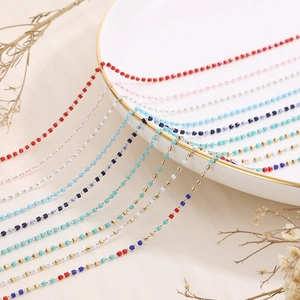 Macro detail of multi-colored glass beads on stainless steel chains for DIY jewelry