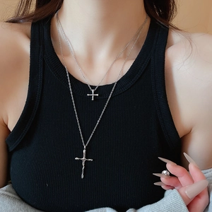 Close-up of double layer silver cross necklace with liquid metal design on model