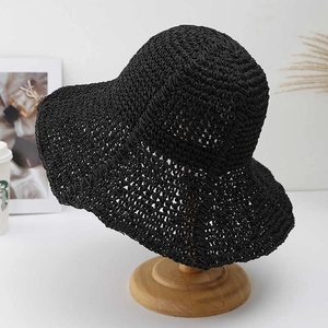 Detail of hand-crocheted black sun hat with breathable hollow-out weave and wavy brim