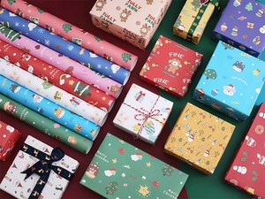 Various Christmas wrapping paper rolls and gift boxes with festive cartoon patterns