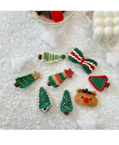 Detailed set of 8 handmade knitted Christmas tree and reindeer hair clips on lace fabric