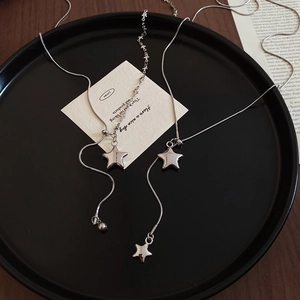 Detail of silver star pendant necklaces featuring snake chain and elegant metallic finish