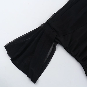 Dettaglio del tessuto a rete arricciato nero e polsini in chiffon con trama trasparente