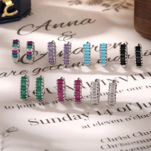 Macro detail of 925 silver hoop earrings featuring multi-color baguette-cut zircons