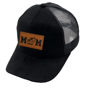 Detail of black trucker hat featuring brown leather MOM patch with cartoon cow design
