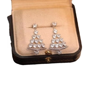 Detailed close-up of sparkling Christmas tree earrings with inlaid rhinestones on a display box