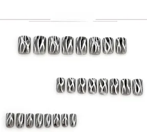Detail view of 24 black gradient press-on nails with silver glitter flame patterns