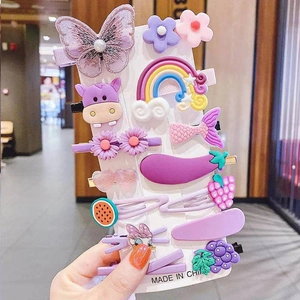 Close-up of 11 purple cartoon hair clips including butterflies and flowers on a display card