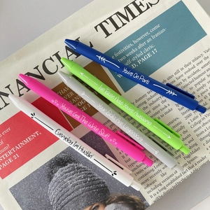 Close-up of 5 colorful gel pens with motivational English slogans on newspaper background
