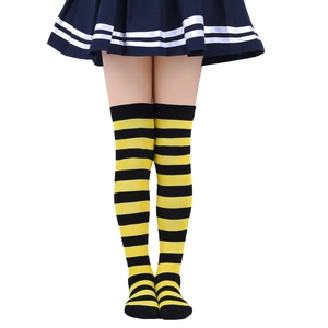 Detailed view of yellow and black striped over-the-knee knitted stockings on model