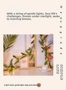 Détail de guirlande LED chaude avec verdure artificielle et décor de pommes de pin