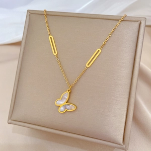 Close-up of golden butterfly necklace with mother of pearl inlay on silk background