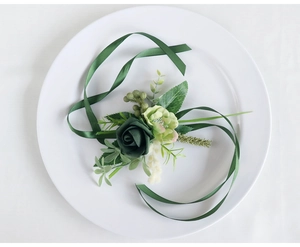 Detail of dark green PE rose boutonniere with forest ribbons for outdoor wedding decor