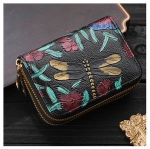 Détail de gaufrage libellule et fleurs sur le portefeuille accordéon en cuir noir