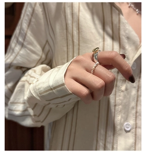 Macro detail of retro S925 silver ring featuring gold accents and small white pearls