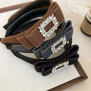 Detail of three flocked rhinestone headbands in brown, dark gray, and black fabric