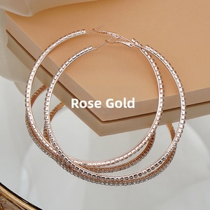 Detailed view of rose gold oversized hoop earrings with pavé white rhinestones and mirror finish