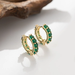 Detailed macro view of 18K gold plated hoop earrings set with emerald green zircons