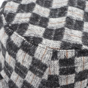 Macro detail of the checkered wool fabric and stitching on this stylish bucket hat