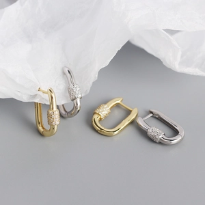 Detail of gold and silver carabiner earrings featuring sparkling zircon pave insets