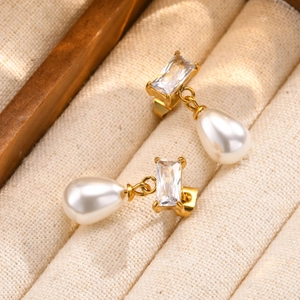 Detail of teardrop pearl earrings with baguette-cut zircon in a luxury vintage style
