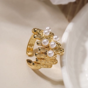 Detailed view of 18K gold irregular textured ring set with six elegant round white pearls
