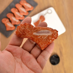 Realistic braised meat food model keychain with glossy texture held in hand