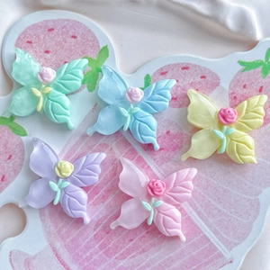 Top view of five colorful resin butterfly charms with small floral centers for hair clips