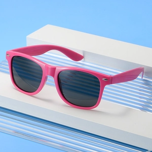Pink Wayfarer sunglasses with dark grey lenses displayed on a blue geometric background