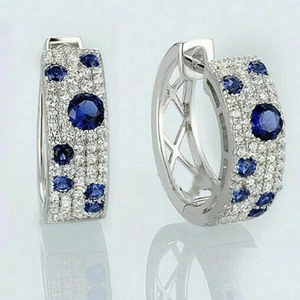 Silver C-shaped hoop earrings with deep blue round gems and micro-pave white zircon stones