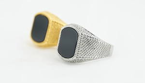 Macro shot of square vintage punk men's rings with black obsidian and textured waffle band