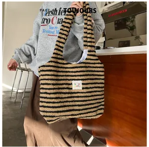 Detailed view of striped plush tote bag with a soft fuzzy texture and woven label