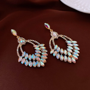 Close-up of golden wheat tassel earrings with shimmering AB rhinestones on satin