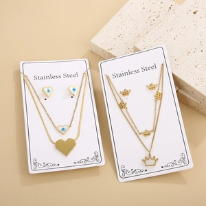 Golden stainless steel heart and crown jewelry set with blue eye detail on stone base