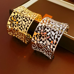 Detailed close-up of gold and silver irregular hollow cutout cuffs on a jewelry box