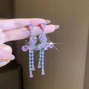 Détail de boucles d'oreilles vintage papillon rose avec pampilles étincelantes