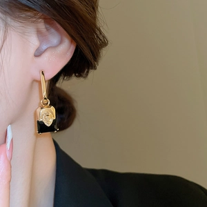 Detail view of lion head earrings with black stone on model for luxury vintage style