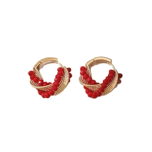 Twisted gold hoop earrings with red crystal beads in a minimalist fashion design