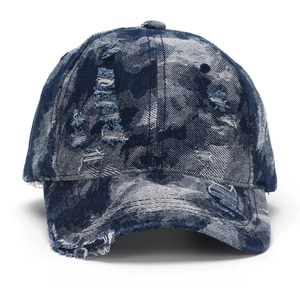Distressed denim baseball cap with vintage rips and washed blue aesthetic on white background