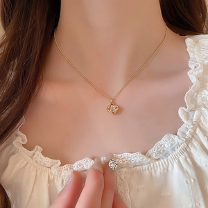 Close-up of 18k gold plated hollow square pendant necklace with zircon on model