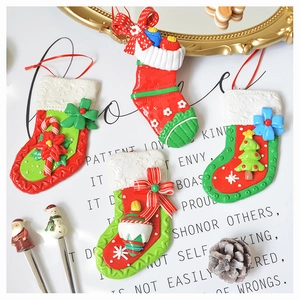 Detailed view of four polymer clay Christmas stocking ornaments with bows and festive patterns