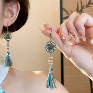 Détails de boucles d'oreilles vintage avec texture solaire en métal et pompons colorés