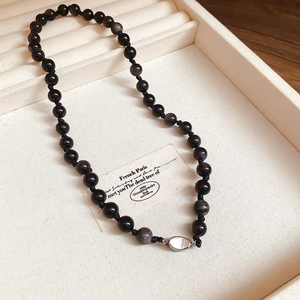 Detail of black obsidian beaded necklace with silver clasp in a jewelry display box