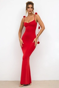 Gros plan sur la décoration de rose 3D et le détail des bretelles d'une robe de soirée rouge