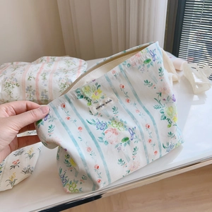 Close-up of floral cotton pouch set with blue stripes and Simple Wish textile label