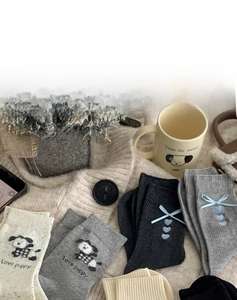 Detail view of cotton knit socks featuring dog embroidery and 3D bow heart accents